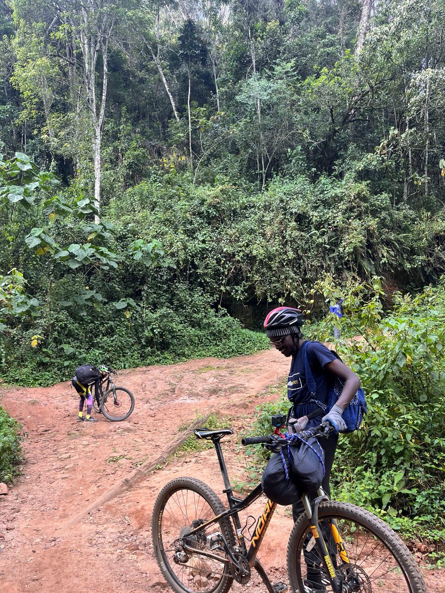 A cyclist smiling on a forest trail on the Congo Nile route